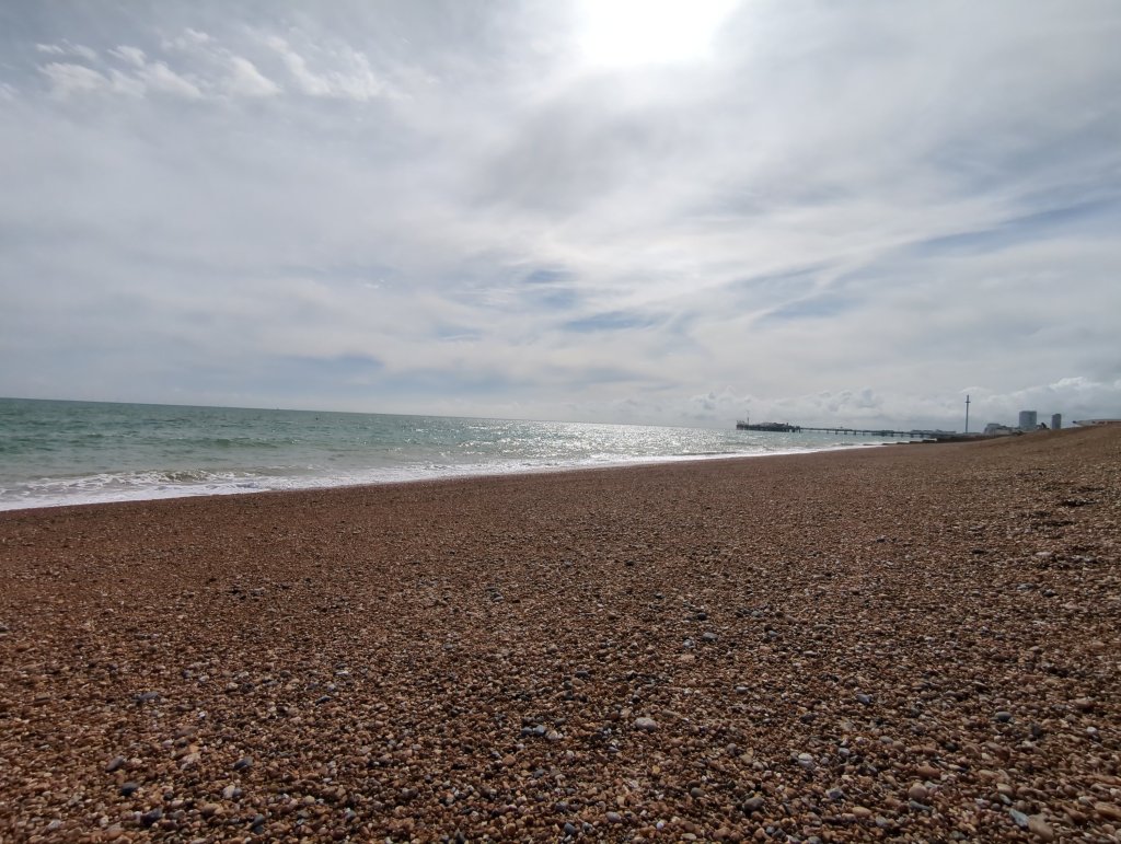 A photo of Brighton beach looking west from the naturist beach, late afternoon, the pier is in the distance.