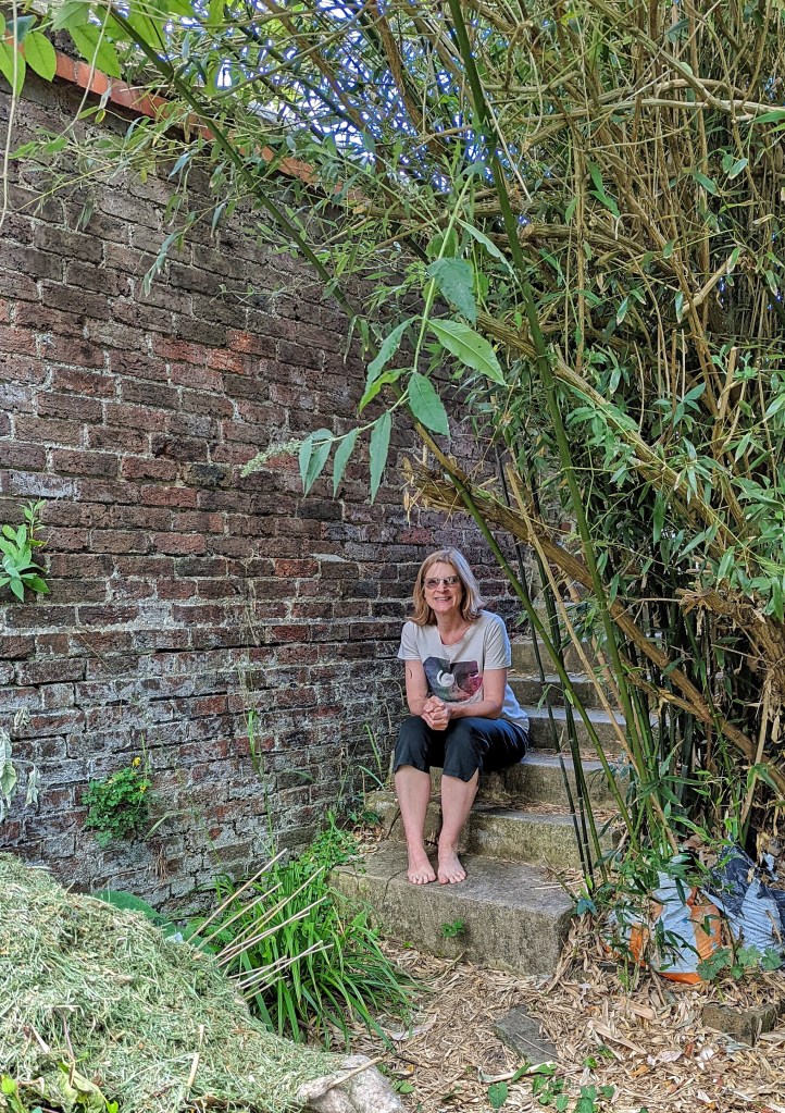 Caroline sitting on steps wearing a Fort Process T-shirt.