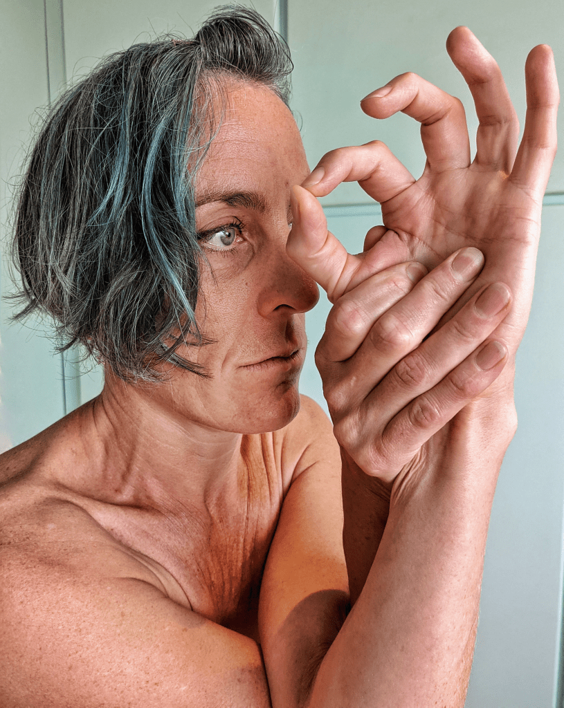 Amma's face from the side, with an eye hand expression.